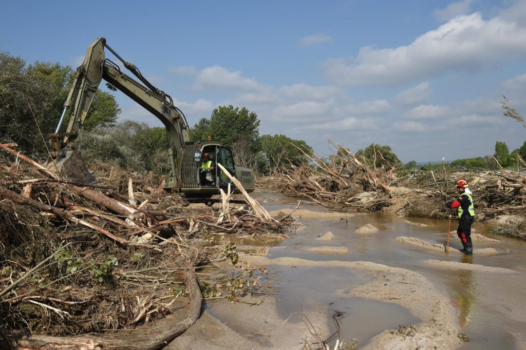 Archivo - Una máquina excavadora y un trabajador durante el dispositivo de búsqueda de los desaparecidos por las lluvias de La Dana.