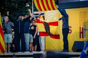 Tres encapuchados queman una bandera española tras un acto de la ANC en plaza Catalunya, Barcelona